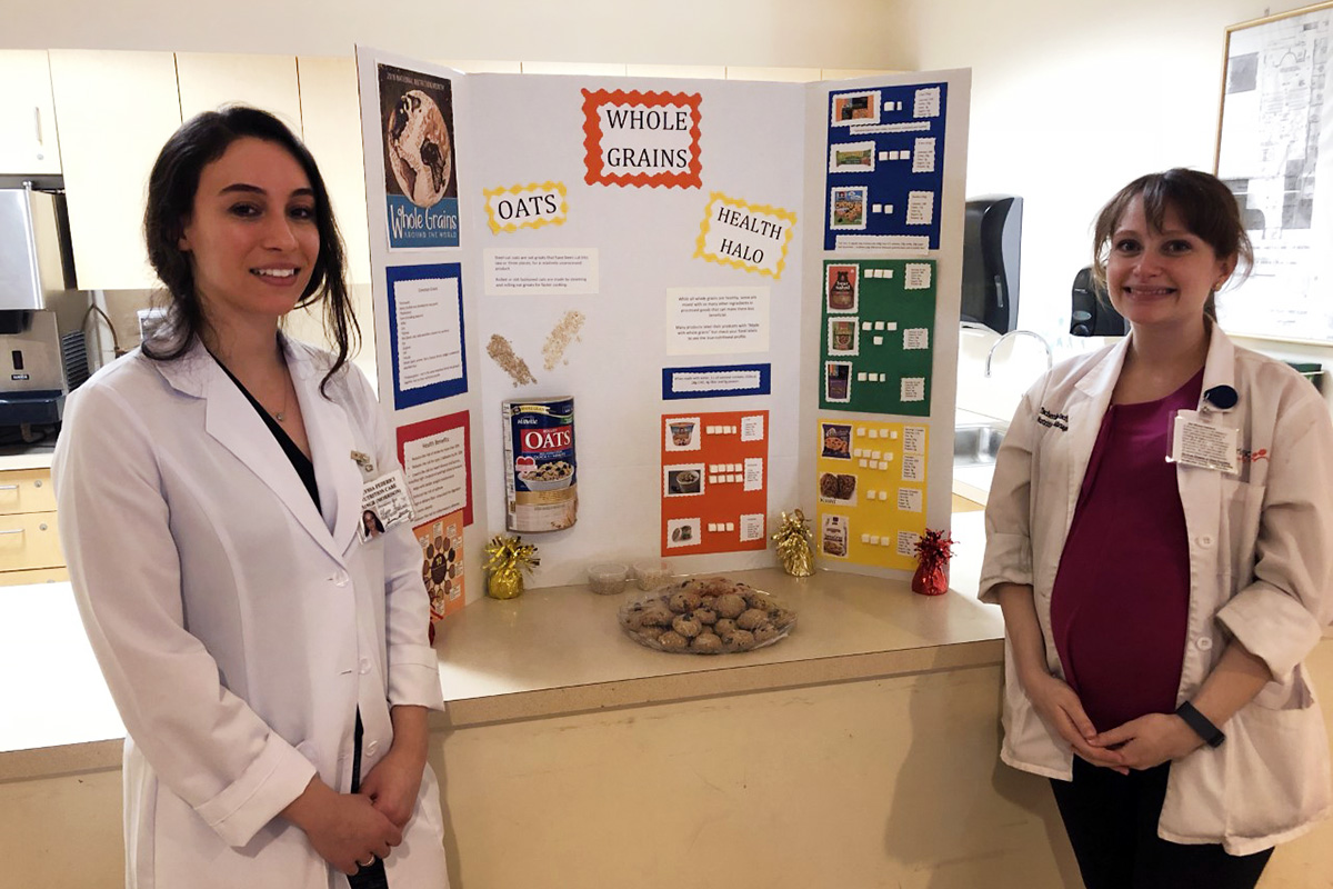 Two female staff members presenting a food nutrition display.